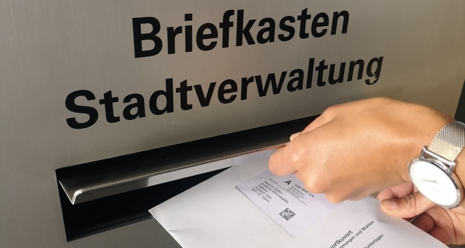 Abstimmungscouvert wird in den Rathaus-Biefkasten geworfen.